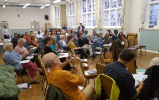 A busy hall full of people participating in a meeting