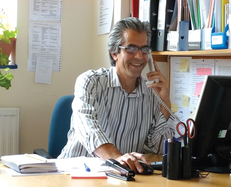 Navid at his desk, on the phone.